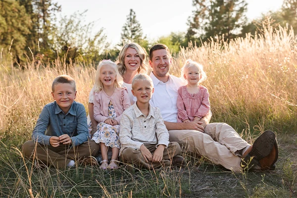 Oral Surgeon Wenatchee WA Brenen Olsen With Family Dr. Brenen Olsen and his family during a professional photoshoot in a field